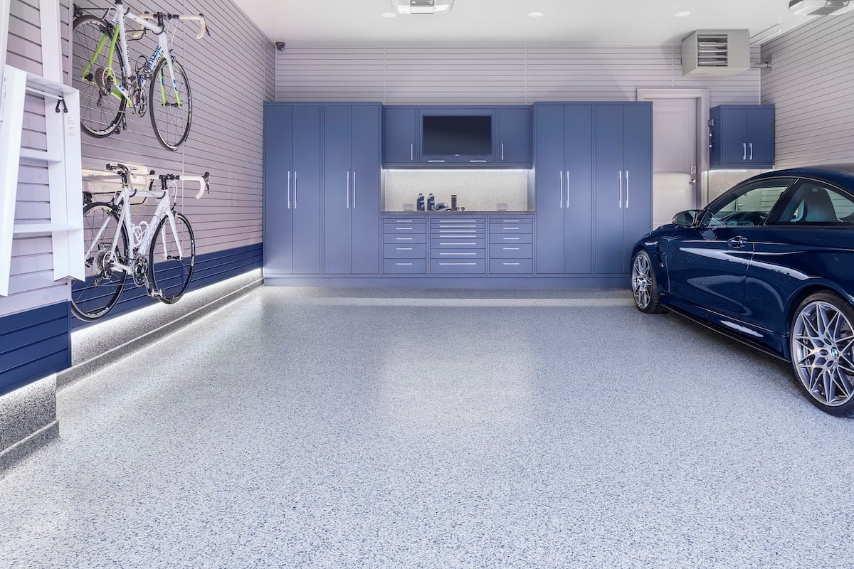 blue car parked in garage with bikes hanging on wall