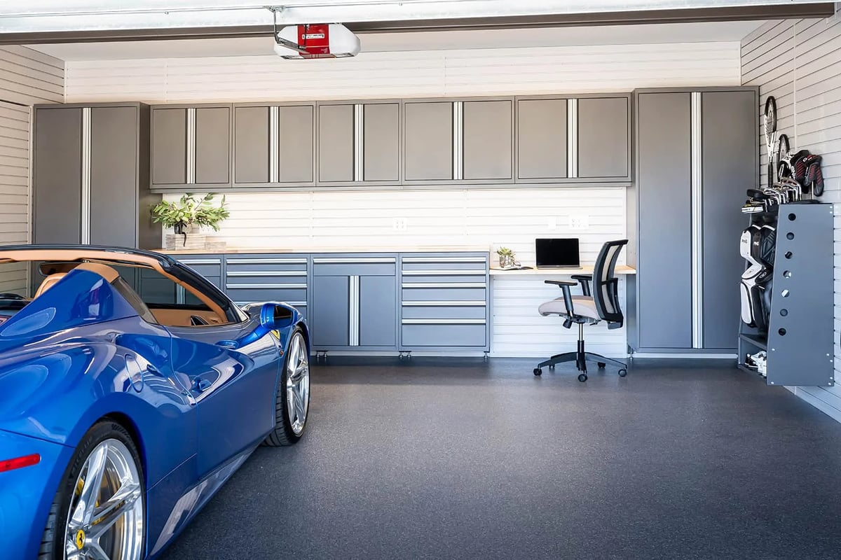 Signature Cabinetry Garage with blue car by Garage Living