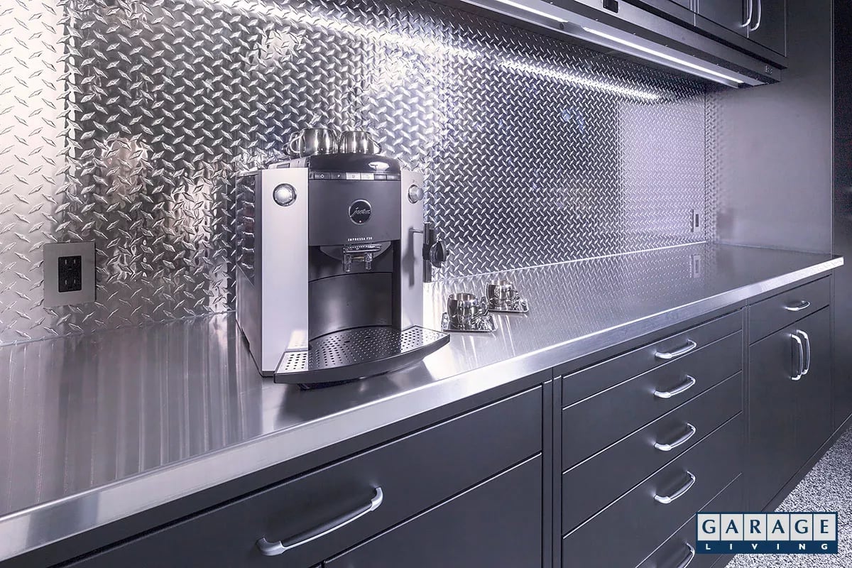 Garage Living Custom Steel cabinetry with a stainless steel countertop and diamond plate backsplash.